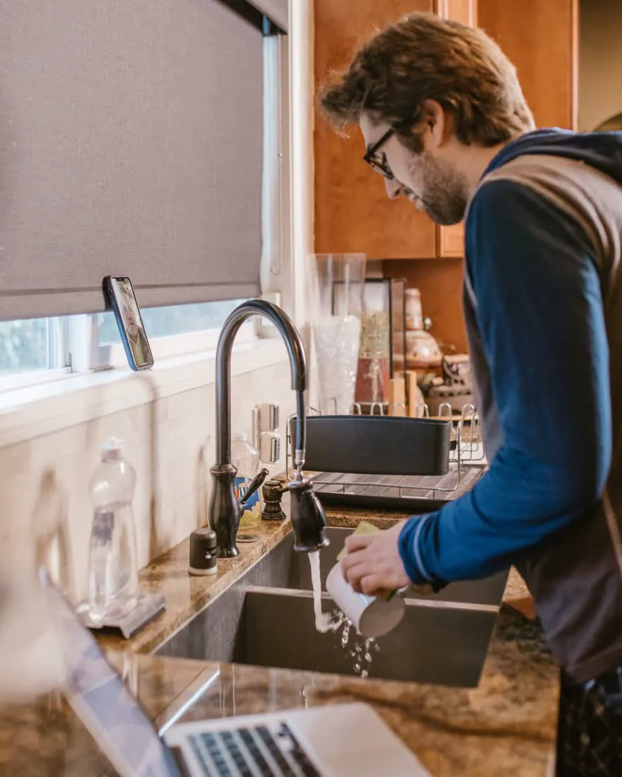 A plumber fitting a kitchen tap